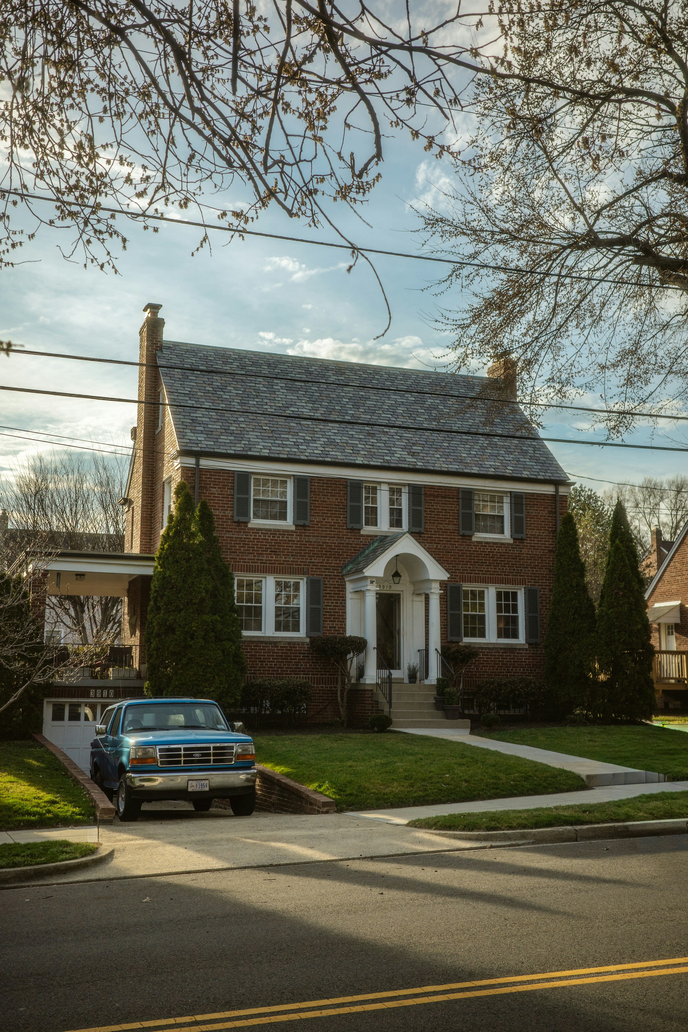 Brick home with a green lawn and mature trees